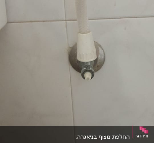 צינור מים מחובר לברז על קיר קרמיקה